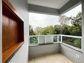 Vista da varanda com vegetação densa ao fundo.