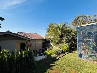Fachada de residência em Lajeado com jardim exuberante e cerca.