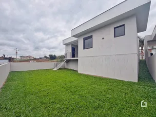 Fachada de uma casa moderna com jardim gramado.