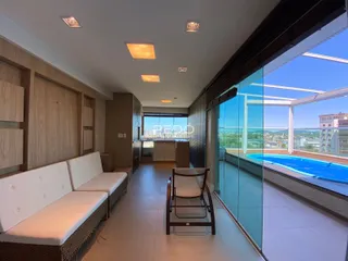 Sala de estar com vista para a piscina e paisagem urbana.