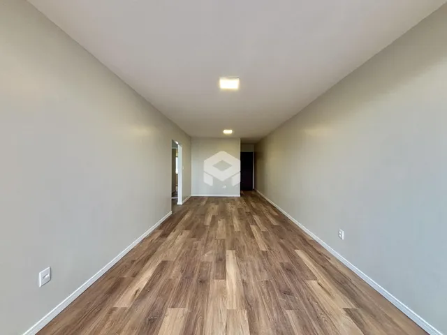 Corredor interno de uma residência com piso de madeira.