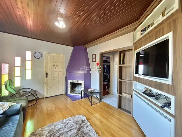 Sala de estar com piso de madeira e lareira em um imóvel no Brasil.