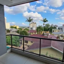 Vista panorâmica da área externa do imóvel mostrando prédios e vegetação.