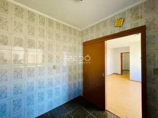 Parede decorada com azulejos brancos e porta de madeira em um ambiente interno.