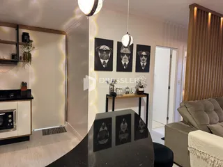 Interior de uma sala de estar com decoração de arte preta e branca.