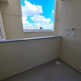 Parede interna de um imóvel mostrando uma janela com vista para o céu azul.