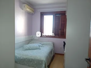 Quarto com cama e janela com persianas de madeira.