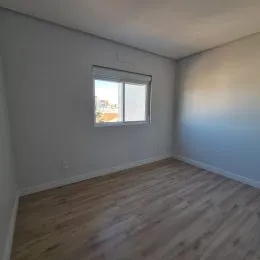 Foto de um cômodo interno com piso de madeira e janela.