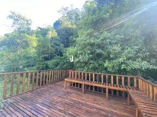 Varanda de madeira com vista para a vegetação.