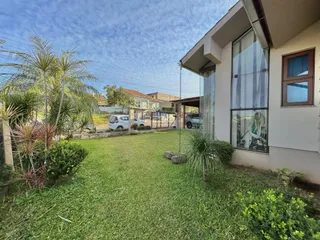 Foto da fachada de uma casa com jardim gramado.