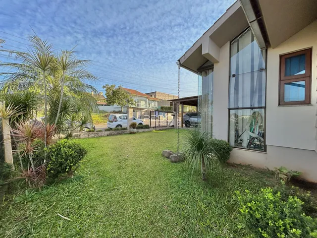 Foto da fachada de uma casa com jardim gramado.