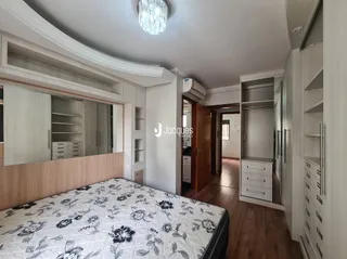 Quarto com cabeceira e armários embutidos de madeira.