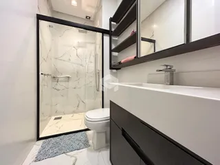 Foto de um banheiro moderno com box de vidro e revestimento de mármore.