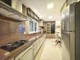 Vista da cozinha moderna com armários e eletrodomésticos em aço inoxidável.
