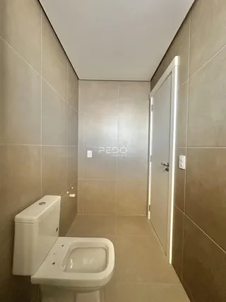 Interior de um banheiro com revestimento cerâmico nas paredes e piso.