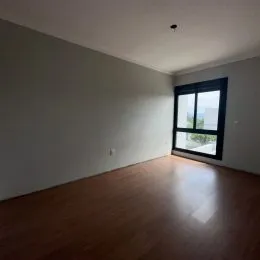 Foto de um cômodo com piso de madeira e paredes brancas.