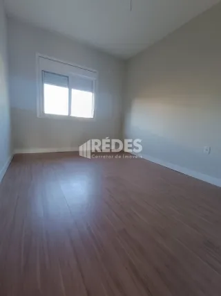 Sala de estar com piso de madeira e janela iluminada.