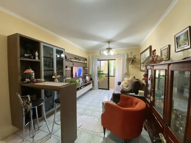 Sala de estar com estantes de madeira e piso de cerâmica clara.