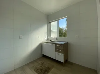 Quarto interno com paredes brancas e piso de madeira.