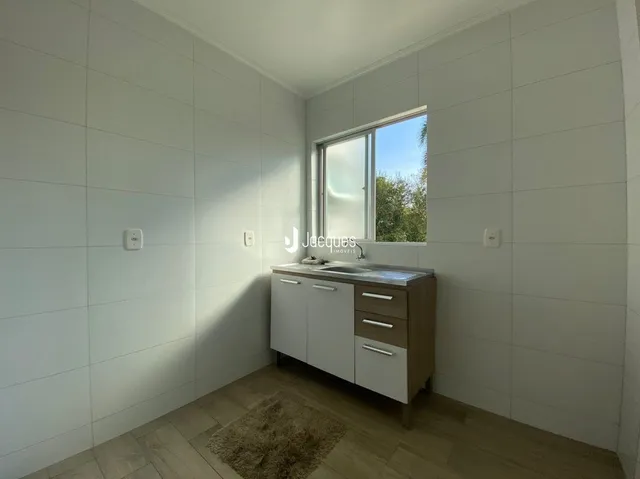 Quarto interno com paredes brancas e piso de madeira.