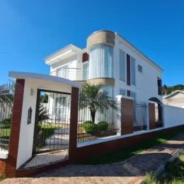 Fachada externa de uma residência branca com portão em Lajeado, Brasil.