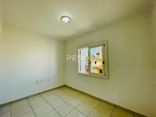 Foto de um ambiente interno com paredes brancas e piso de cerâmica.