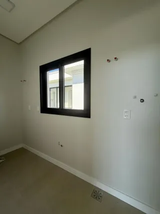 Foto de uma parede interna com uma janela escura.