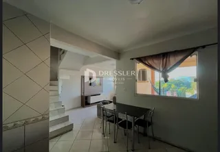 Vista interna de um corredor com escadas e janela em um imóvel no Brasil.