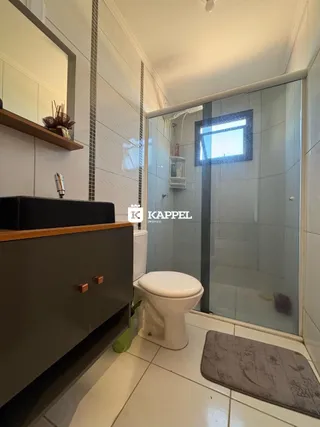 Foto de um banheiro interno com azulejos brancos e box de vidro.