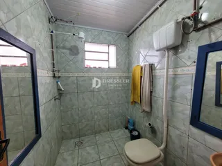 Foto de um banheiro com revestimento de azulejos claros.