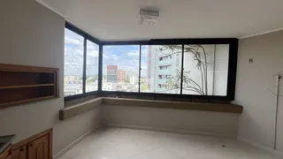 A sala de estar exibe uma parede com uma grande janela que oferece uma vista da paisagem urbana.