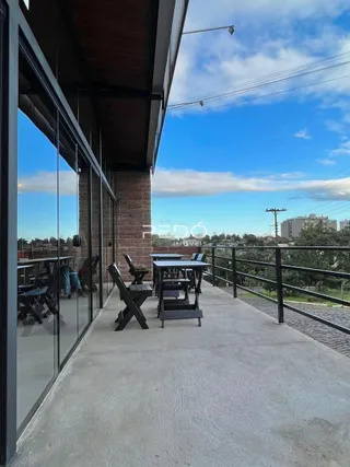 Área externa com piso de concreto e mobiliário de jardim.