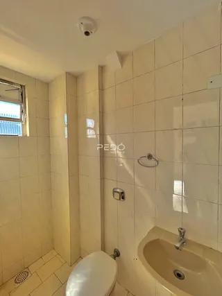 Foto de um banheiro com revestimento cerâmico claro.