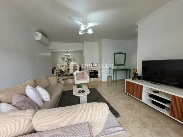 Sala de estar com sofá e televisão em ambiente claro.