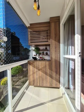 Sala com revestimento de madeira e porta de vidro que dá para a vista.