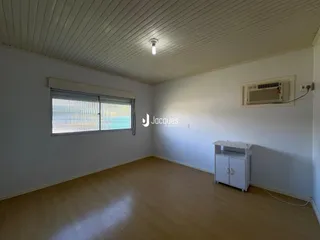 Esta é uma foto de uma sala com piso de madeira clara e teto de painéis brancos.