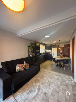 Sala de estar com sofá escuro e piso de cerâmica claro.