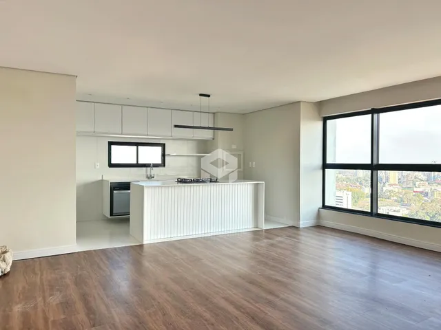 Sala de estar e cozinha moderna com piso de madeira clara.