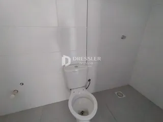 Foto de um banheiro com revestimento branco.