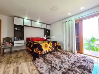 Quarto com cama e vista para a área externa.
