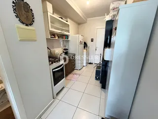Vista interna de uma cozinha com armários brancos e piso de cerâmica.