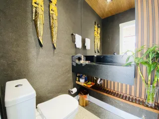 Foto de um banheiro com revestimento de parede cinza e detalhes em madeira.