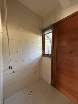 Interior de um ambiente com revestimento cerâmico e porta de madeira.