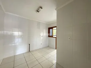 Corredor com piso de cerâmica branca e paredes brancas.