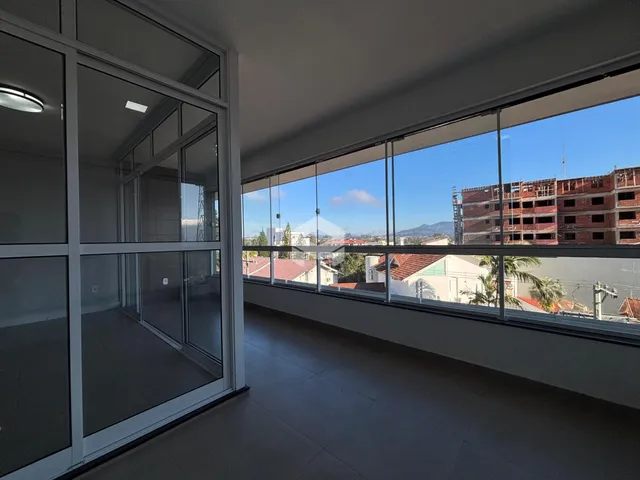 Ambiente interno com grandes janelas que oferecem vista para o exterior.