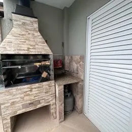 Uma lareira de pedra com um revestimento rústico está visível na área interna.