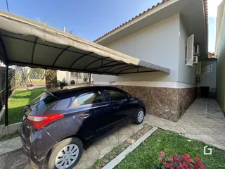 Vista da fachada de uma casa em Lajeado, Brasil, com um carro estacionado na frente.