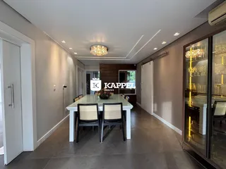 Uma sala de jantar com mesa branca e cadeiras escuras.