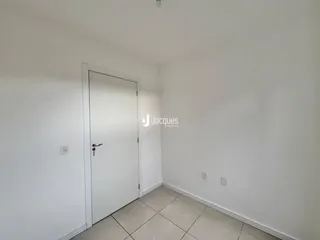 Hall da frente de um cômodo com porta branca.