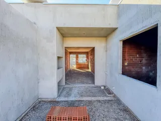 Vista de um corredor de concreto entre duas estruturas.